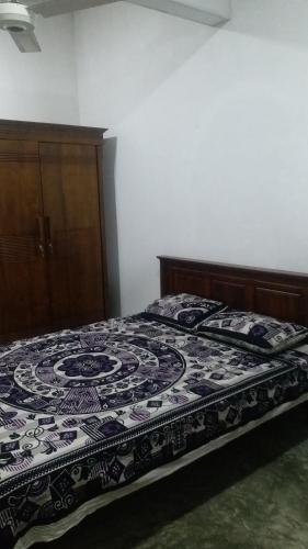 ein Bett mit einer schwarz-weißen Decke drauf in der Unterkunft Rock house kurunegala in Kurunegala