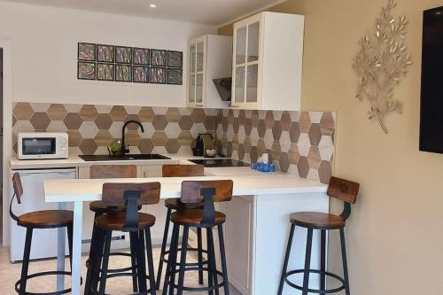 une cuisine avec un comptoir et des tabourets de bar dans l'établissement Le REGENCY, appartement familial au cœur du centre-ville, des célèbres jardins Biovès, et seulement à 1 minute à pied de la plage, à Menton