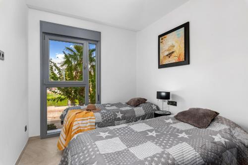 a bedroom with two beds and a window at Luxusní apartmán ve Španělsku, Cabo Roig in Playas de Orihuela