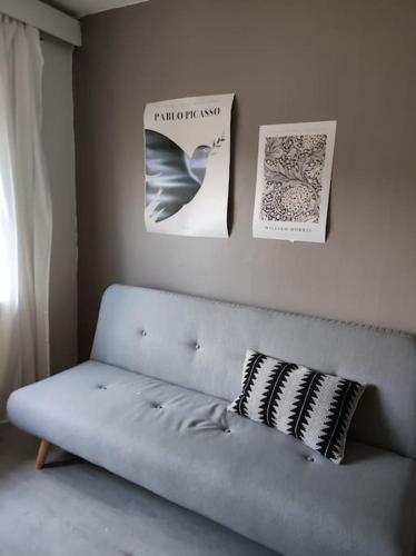 eine Couch in einem Wohnzimmer mit Plakaten an der Wand in der Unterkunft Spacious and charming studio in Rovaniemi