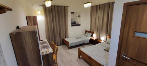 ノヴィ・ソンチにあるKEISA APARTRoomsのベッド1台付きの小さな部屋とベッド2台付きの部屋