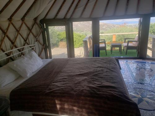 a bedroom with a bed and a view of a patio at Villa Elia with pool, Yurt and sea views in Kos Town