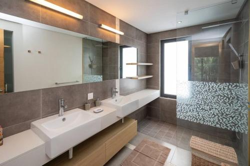 a bathroom with two sinks and a shower at Wonderful Mont Choisy flat, huge lagoon pool in Mont Choisy