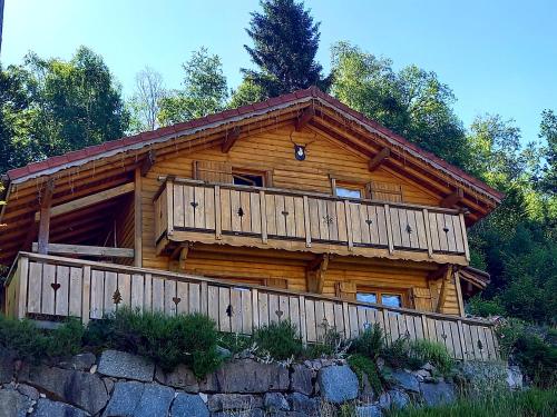 a log cabin with a balcony on top of a wall at Chalet Typique Vosgien "les Barbotines" in Ventron