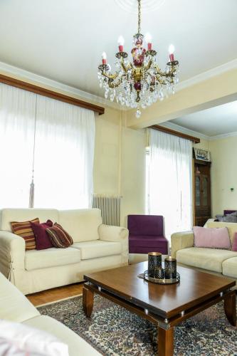 a living room with a chandelier and a coffee table at Maria's House in Alexandroupoli