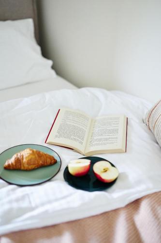 een boek en een bord eten op een bed bij Resort Zacisze Apartamenty in Konopnica