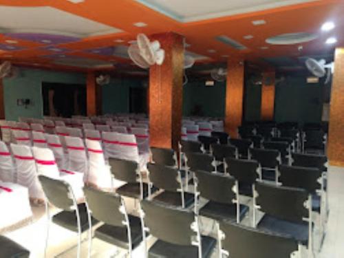 an empty auditorium with white chairs in a room at Hotel S.S.Palace Samastipur, Samastipur in Samastīpur