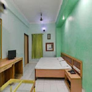 Cette chambre comprend un lit et un mur vert. dans l'établissement Hotel Sagar Inn - Bihar, à Samastīpur