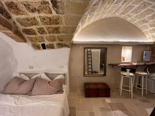 ein Schlafzimmer mit einem Bett und einer Steinmauer in der Unterkunft La Segreta del Castello Self Check-in, private access in Gioia del Colle