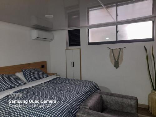 a bedroom with a bed and a chair and a window at Aparta estudio moderno in Envigado
