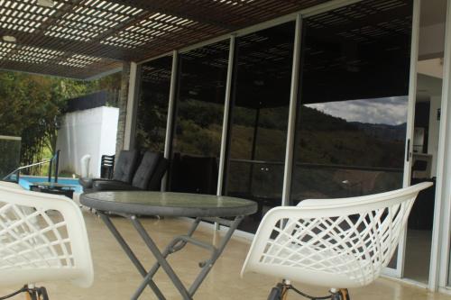 uma mesa e cadeiras num pátio com vista para as montanhas em Mansion 16 em Medellín