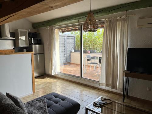 - un salon avec une grande porte coulissante en verre donnant sur une terrasse dans l'établissement Duplex lumineux sur gde TERRASSE, BALNEO double, parking privé, CLIM, local vélos, à Entraigues-sur-la-Sorgue