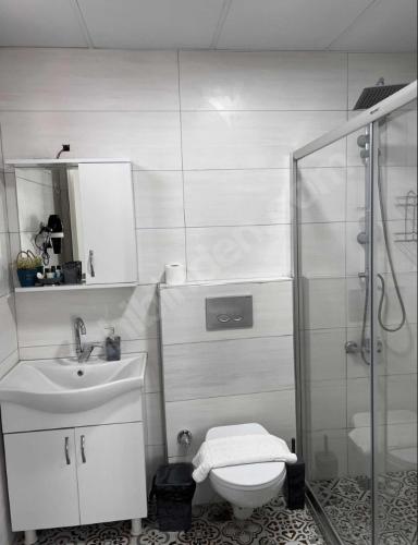 uma casa de banho com um chuveiro, um WC e um lavatório. em GDL OTEL em Samsun