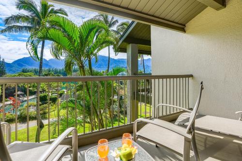 a balcony with a table and chairs and palm trees at Hanalei Bay Resort 2301 two in Princeville