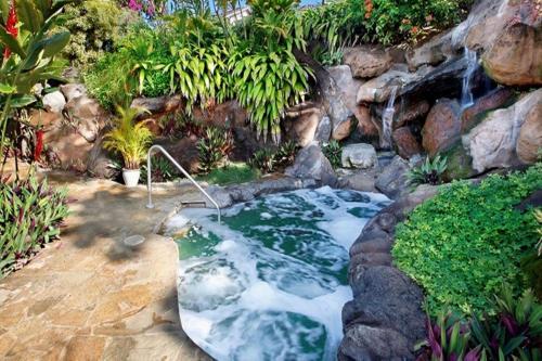 a stream in a garden with a waterfall at Hanalei Bay Resort 2301 two in Princeville