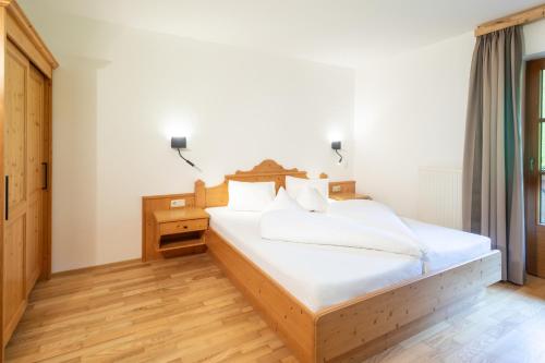 a bedroom with a large bed with white sheets at Landhaus Zaglauhof in Werfenweng