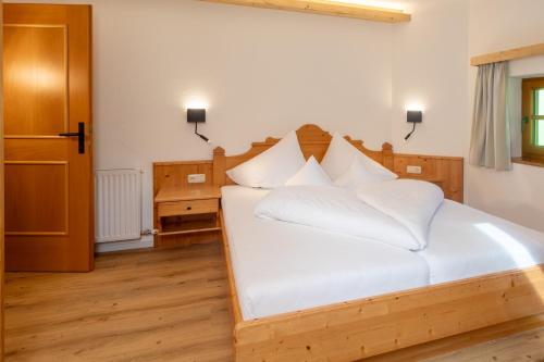 a bedroom with a white bed with white pillows at Landhaus Zaglauhof in Werfenweng