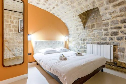 une chambre avec un grand lit dans un mur de briques dans l'établissement Nouveau - Industrial Appartement - 6p - Gym/Sauna, à Paris