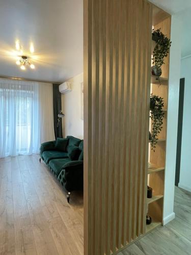 una sala de estar con un sofá verde en una habitación en Apartament central 2 camere en Râmnicu Vâlcea