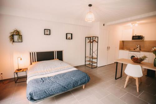 a bedroom with a bed and a desk and a kitchen at Franc-Bisontin - Unique ! 4 logements disponibles in Besançon