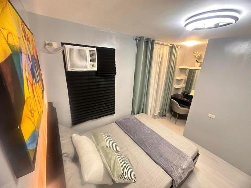 um pequeno quarto com uma cama e uma janela em Portville Mactan near Airport em Lapu Lapu City