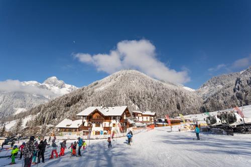 a group of people standing in the snow in front of a ski lodge at Landhaus Zaglauhof in Werfenweng