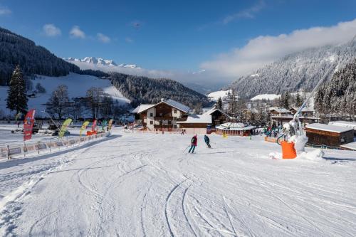 a group of people skiing down a snow covered slope at Landhaus Zaglauhof in Werfenweng