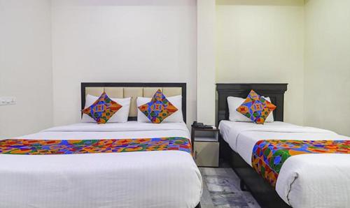 1 Schlafzimmer mit 2 Betten und bunten Kissen in der Unterkunft FabHotel LP MVP Colony in Visakhapatnam