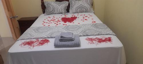białe łóżko z czerwoną krwią w obiekcie Royal Vybez Vacation Homes w mieście Spanish Town