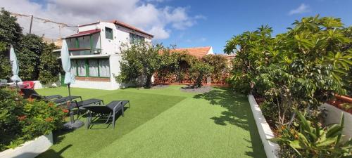 a yard with chairs and trees and a house at Villa Clara in San Sebastián de la Gomera