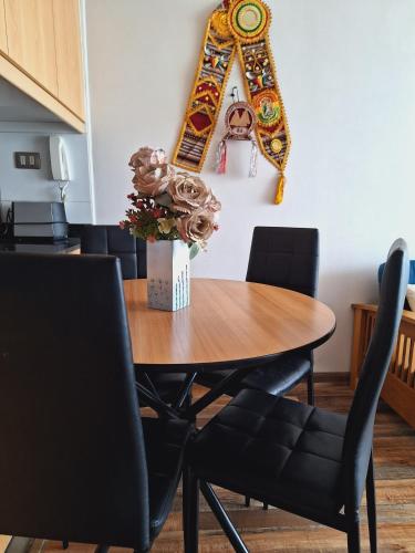 een eettafel met stoelen en een spiegel aan de muur bij Nautilus vista al mar in Iquique