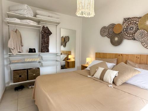 een slaapkamer met een groot bed en een spiegel bij Villa Rosa Fuerteventura in Corralejo