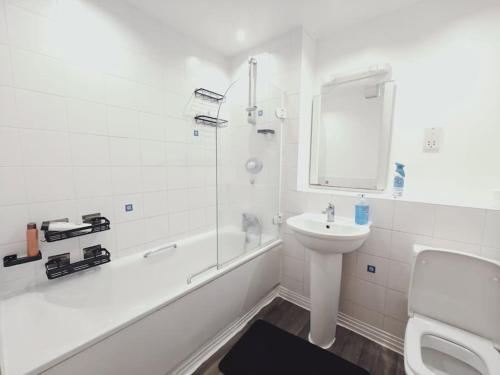 a bathroom with a sink and a toilet and a bath tub at Barking 1 bed flat With Parking in Barking