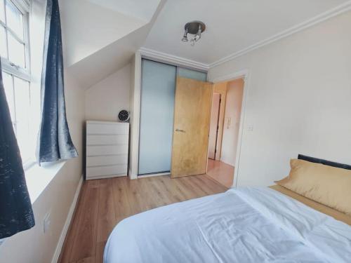 a bedroom with a white bed and a window at Barking 1 bed flat With Parking in Barking
