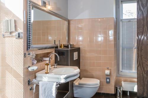 a bathroom with a sink and a toilet and a mirror at La Maison d'Igor in Morges