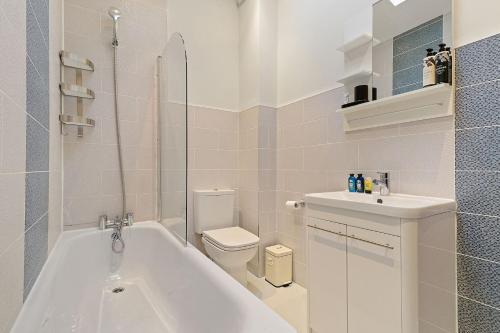 倫敦的住宿－The Hoxton Loft - Top Floor Shoreditch Apartment，带浴缸、卫生间和盥洗盆的浴室
