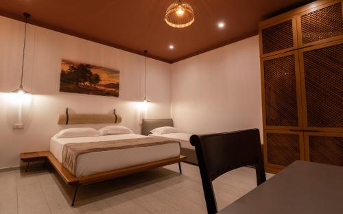a bedroom with two beds and a table and a chair at Kronos Hotel in Durrës