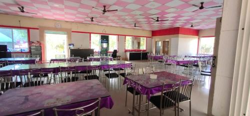 a banquet hall with purple tables and chairs at KINGS COCO RESORT in Konārka