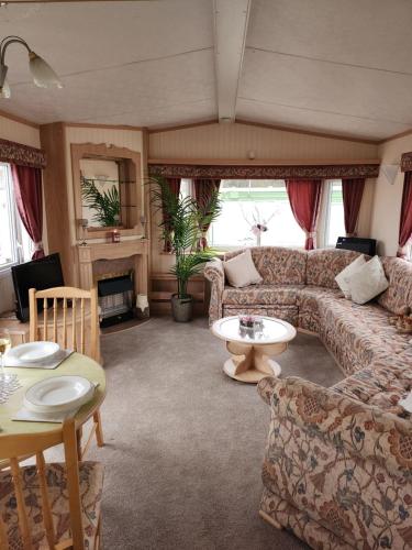a living room with a couch and a table at The promenade, nr to fantasy island minimum 3 nights stay in Ingoldmells