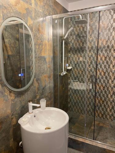 a bathroom with a sink and a shower with a mirror at Ami Residence Bucharest Airport&Therme&Parking in Otopeni