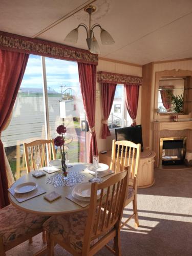 a dining room with a table and chairs with a view at The promenade, nr to fantasy island minimum 3 nights stay in Ingoldmells
