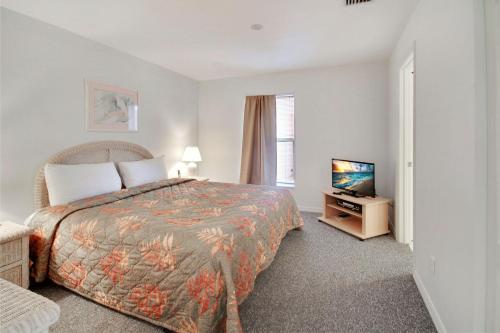 a bedroom with a bed and a television in it at Amadeus 7 in St Pete Beach