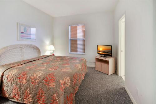 a small bedroom with a bed and a television at Amadeus 2 in St. Pete Beach
