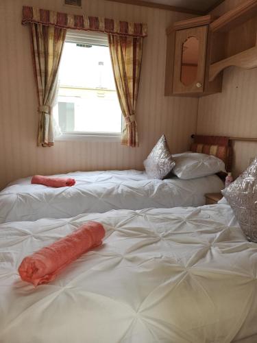 a room with three beds with a window at The promenade, nr to fantasy island minimum 3 nights stay in Ingoldmells