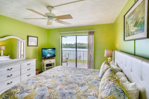 a bedroom with green walls and a bed with a ceiling fan at Bayshore Yacht & Tennis 216 in Clearwater Beach