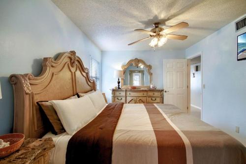 a bedroom with a large bed with a ceiling fan at Emerald Isle 101 in St. Pete Beach