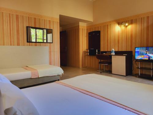 ルセにあるRoger's Hotelのベッド2台、薄型テレビが備わるホテルルームです。
