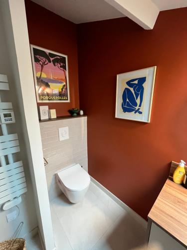een badkamer met een toilet in een rode muur bij Loft de Juliette à Saint-Malo in Saint-Malo
