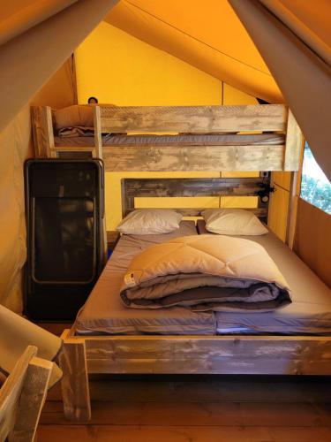 a bedroom with two bunk beds in a tent at Oh! Campings - L'Espiguette in Le Grau-du-Roi