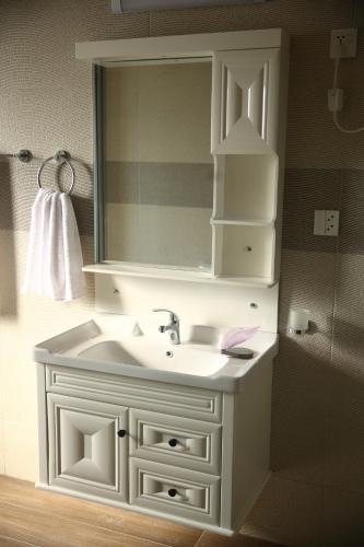 a bathroom with a white sink and a mirror at Gulberg Suites in Lahore